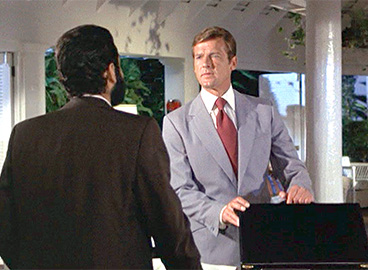 a man in suit talking to another man